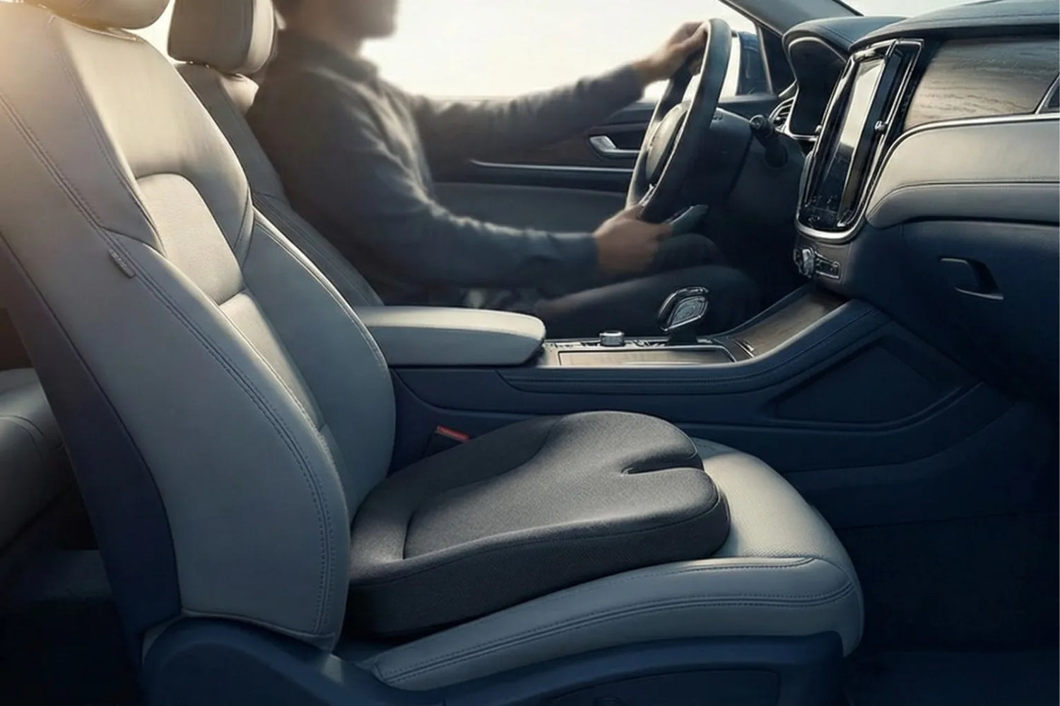 Bannière d’article montrant un coussin d’assise ergonomique sur le siège d’une voiture moderne, illustrant l’amélioration du confort pendant les trajets longue durée.