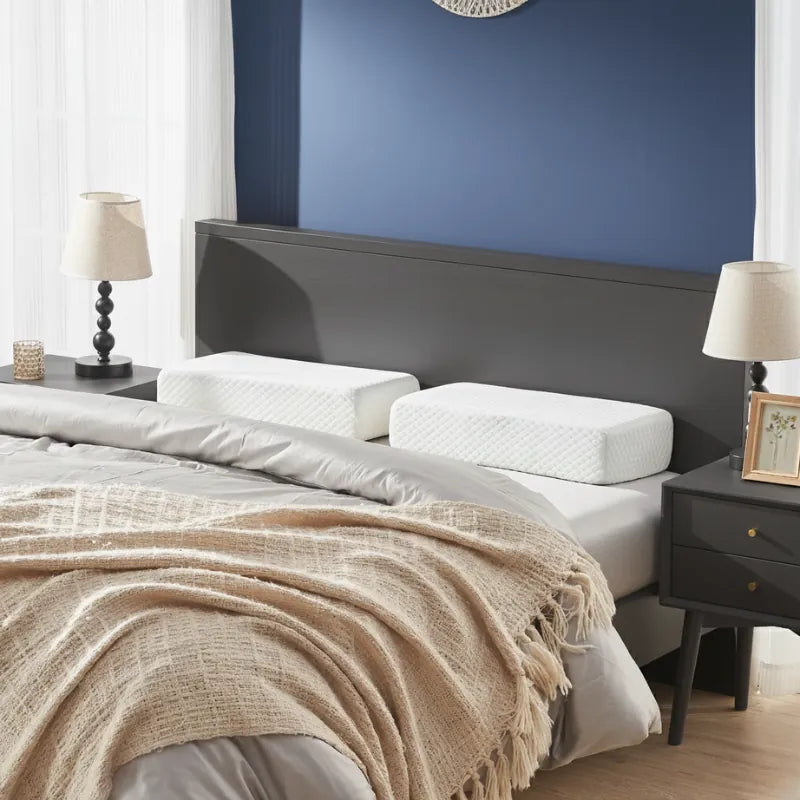 Deux oreillers gel rafraichissant à mémoire de forme 60x30cm posés sur un lit dans une chambre au mur bleu profond, drap satiné gris perle et tête de lit bois clair, ambiance premium et apaisante