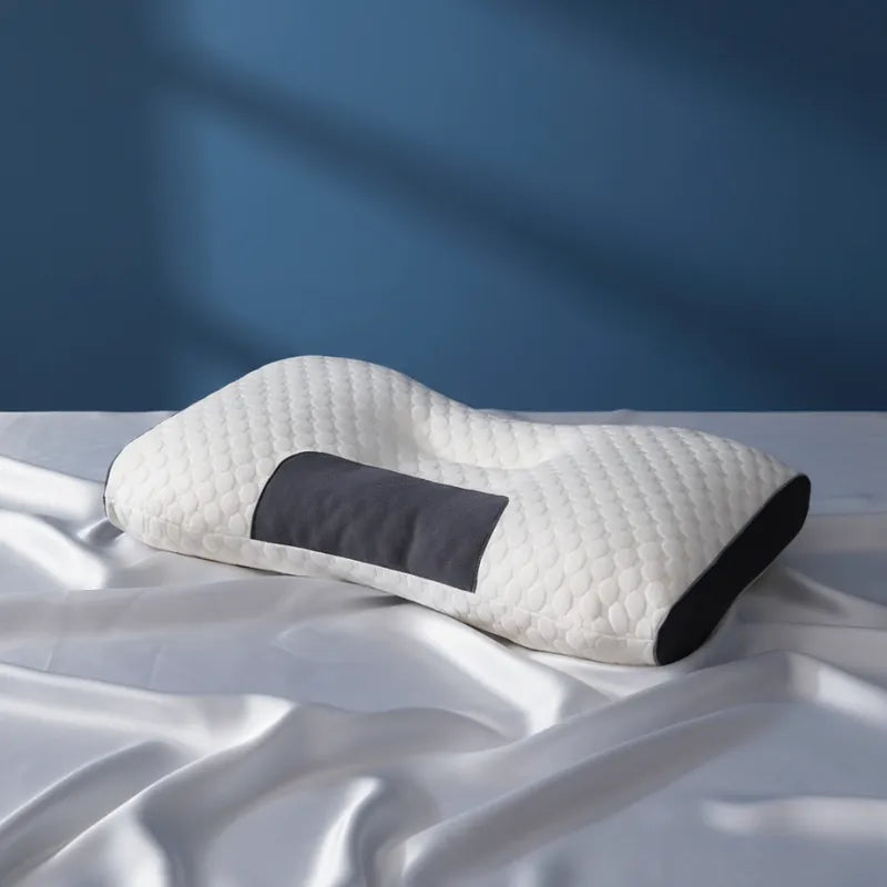 oreiller ergonomique cervical 50x70 13 cm sur drap satiné gris perle, mur bleu profond, lumière naturelle diffuse