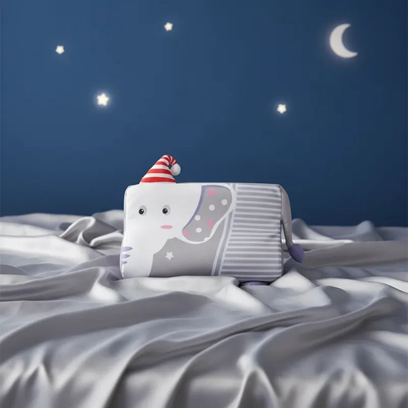 oreiller memoire de forme enfant elephant posé sur drap gris perle, fond bleu nuit avec étoiles, style doux et premium
