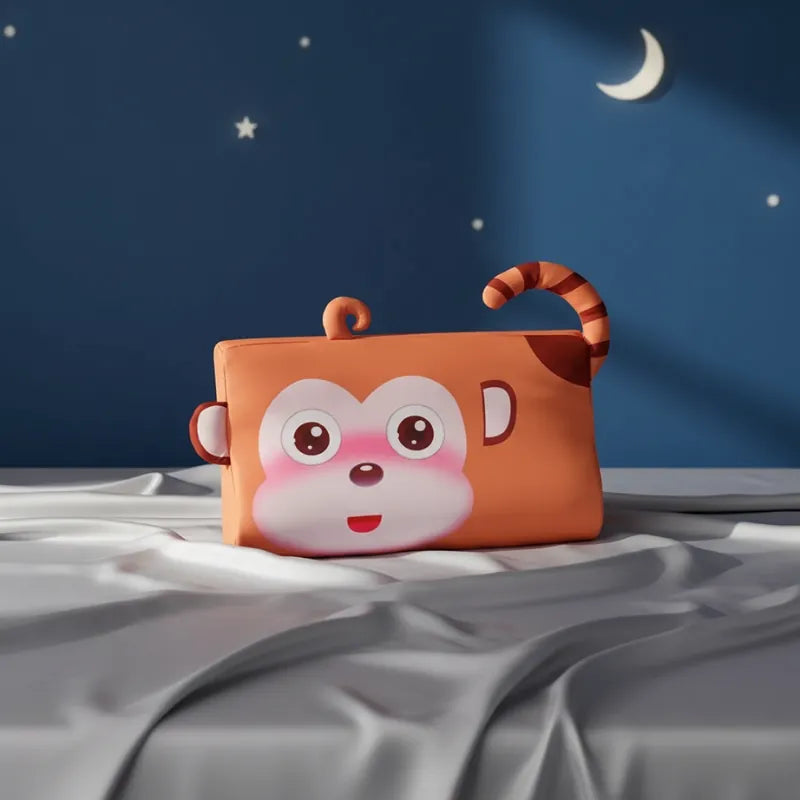 oreiller memoire de forme enfant singe posé sur un drap gris perle, fond bleu nuit avec lune et étoiles, design doux et ludique