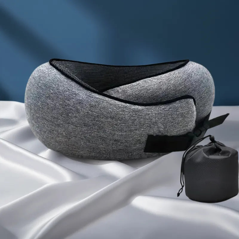 Oreiller mémoire de forme voyage à clips ajustable gris foncé, coussin cervical ergonomique pour avion ou voiture, sur drap satiné gris perle et mur bleu profond