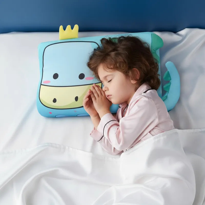 Enfant endormi paisiblement sur un oreiller mémoire de forme enfant dinosaure dans une ambiance douce et premium