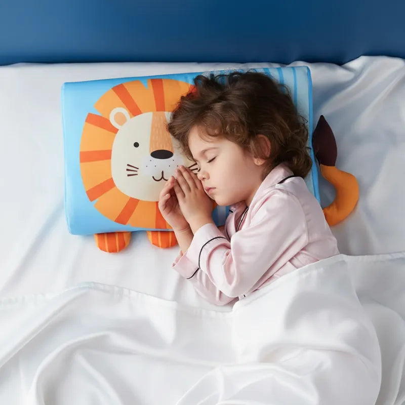 Enfant endormi paisiblement sur un oreiller mémoire de forme enfant lion dans une ambiance douce et premium