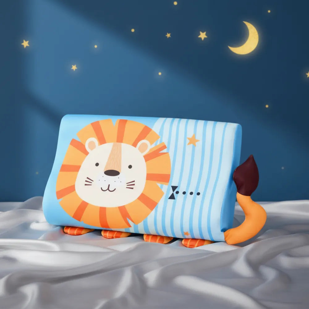Oreiller ergonomique en mémoire de forme pour enfant — modèle ludique avec motif lion, conçu pour offrir confort et bon maintien cervical, présenté sur un drap satiné gris perle devant un mur bleu profond étoilé.