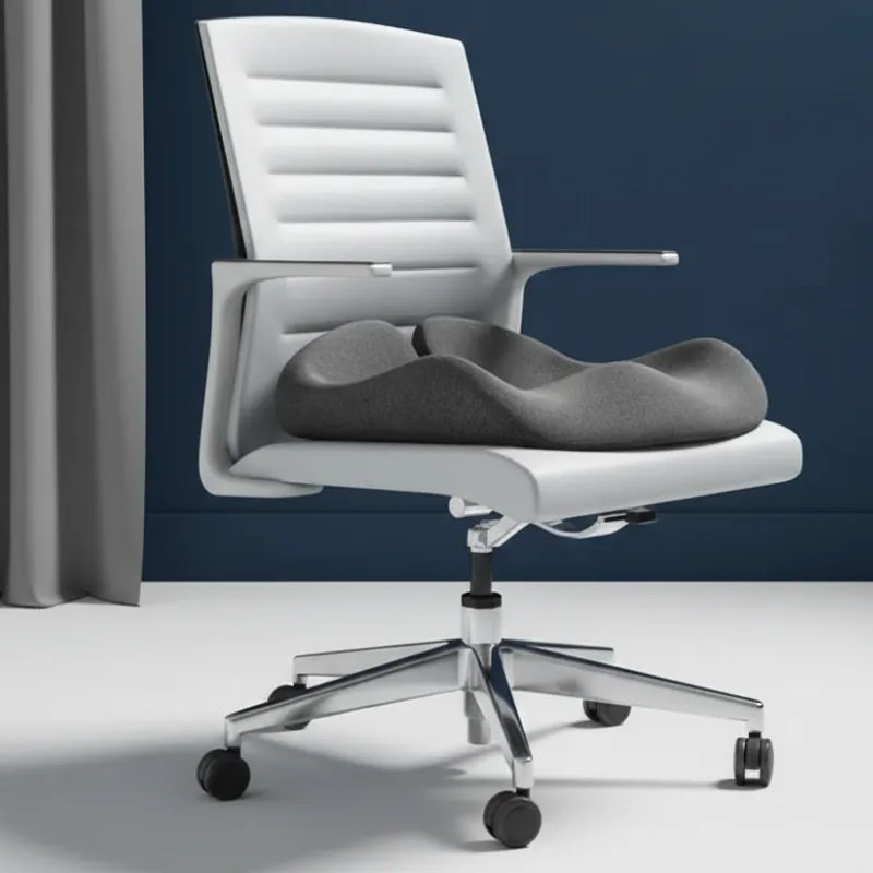 Coussin ergonomique pour fauteuil de bureau gris foncé posé sur chaise de travail blanche