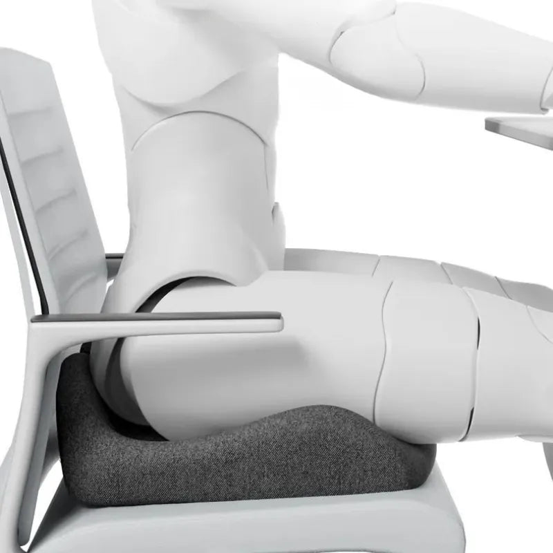 Vue de profil d’un coussin ergonomique pour fauteuil de bureau gris foncé avec mannequin assis pour illustrer la posture au bureau