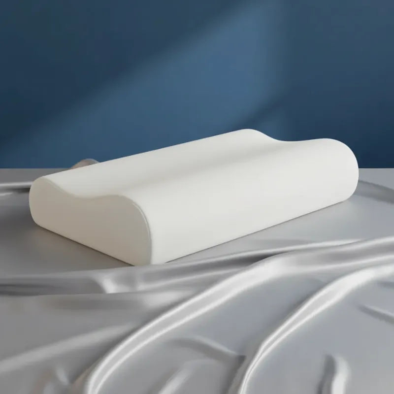 Oreiller à mémoire de forme bambou sans housse premium posé sur un drap satiné gris perle, devant un mur bleu.