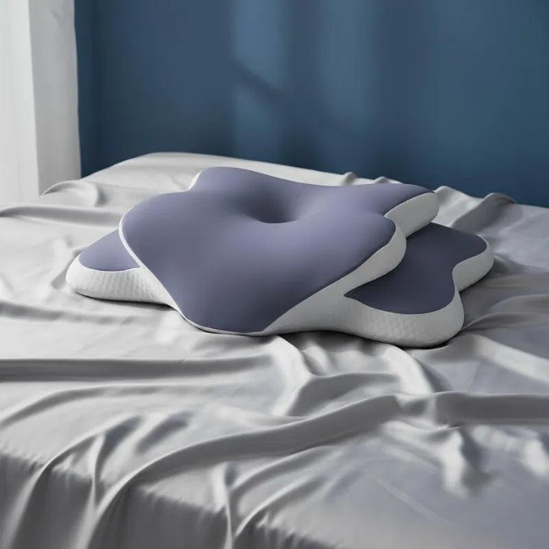 Oreiller mémoire de forme douleur cervicale violet 40x65cm sur un drap gris perle lumineux devant un mur bleu profond et apaisant