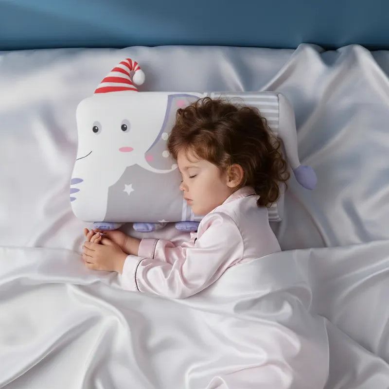 Enfant endormi paisiblement sur un oreiller mémoire de forme enfant elephant dans une ambiance douce et premium